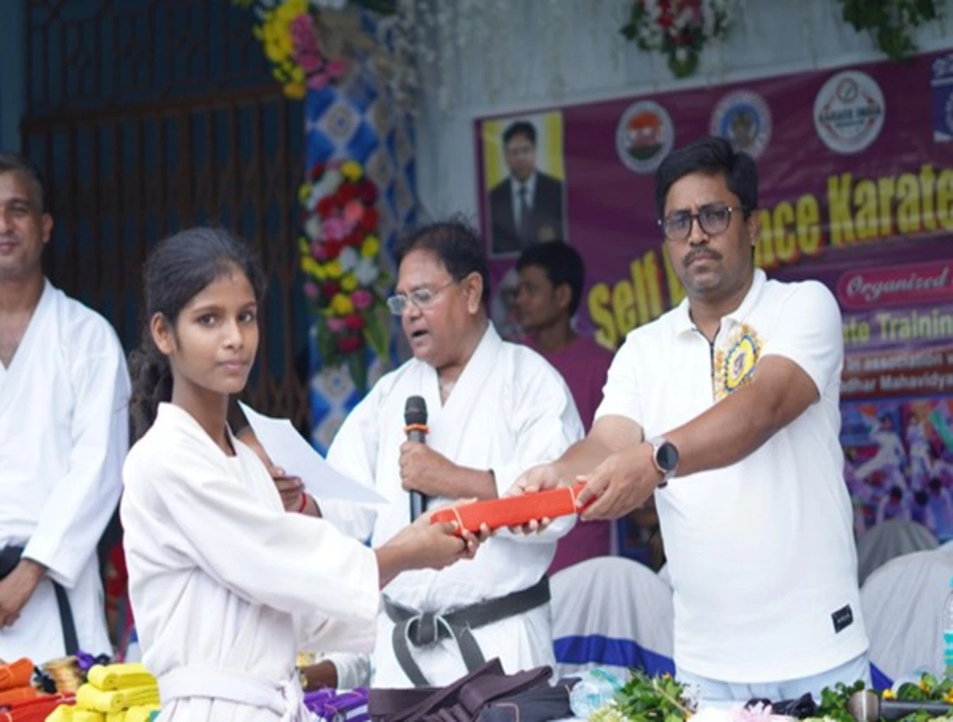 Students receiving karate belts and certificates at Gram Tarakki